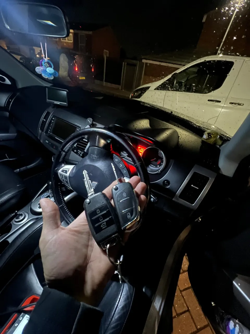 Keys held at the steering wheel inside a Mitsubishi during key programming