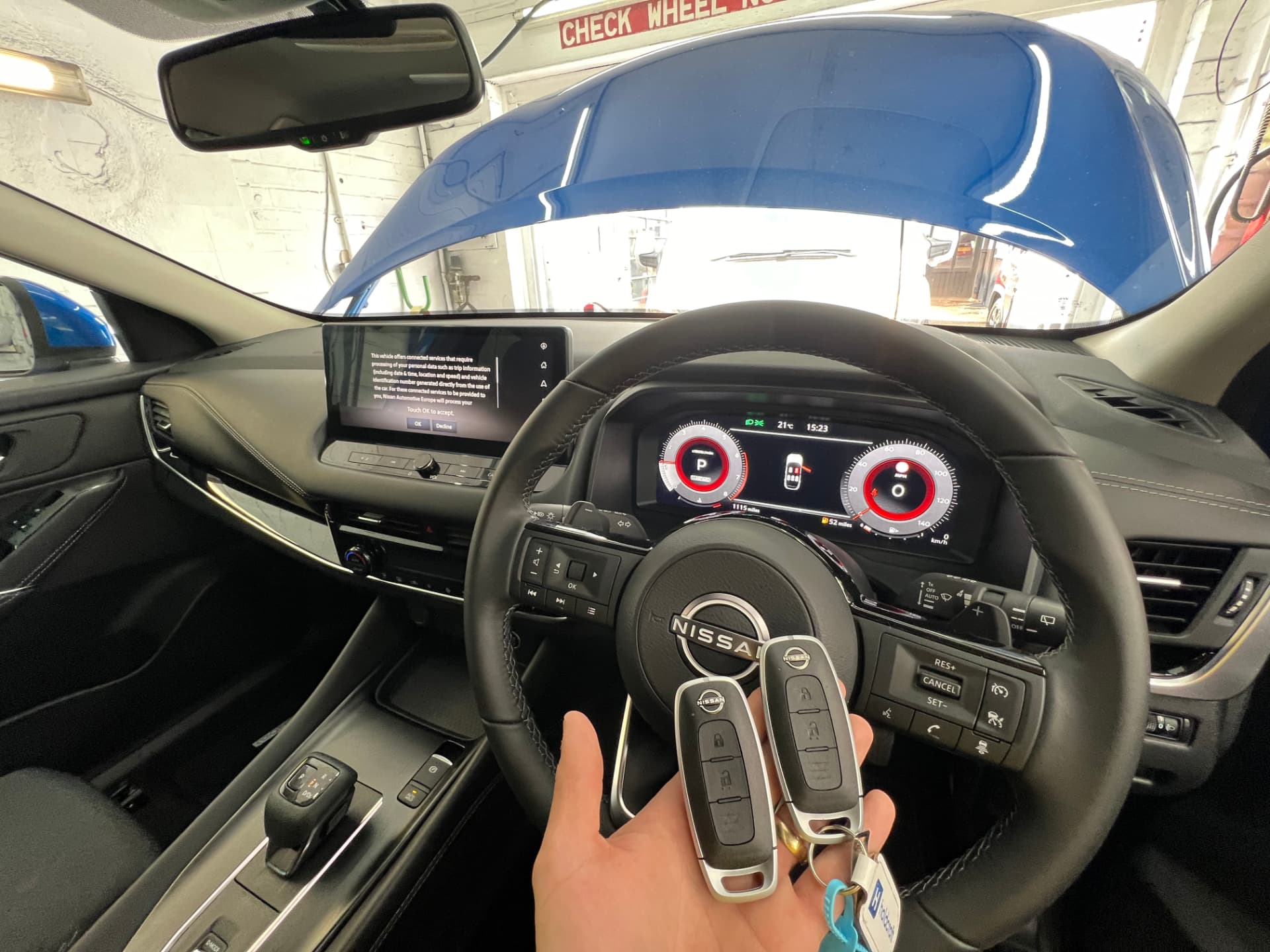 Nissan smart keys held inside a modern Nissan interior during key programming